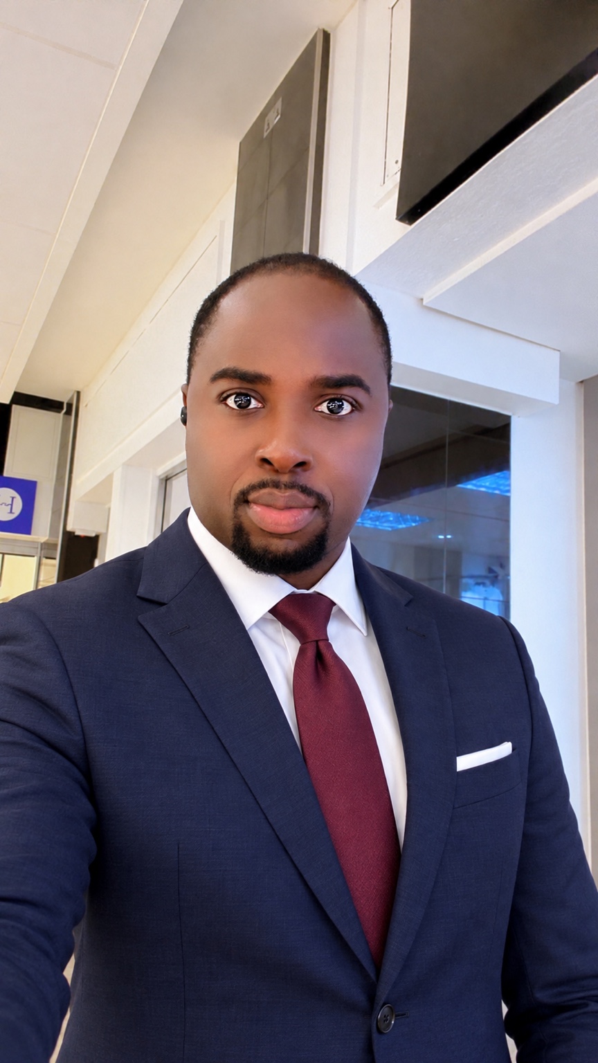 Dr E. Adjei Boateng in a navy suit and burgundy tie